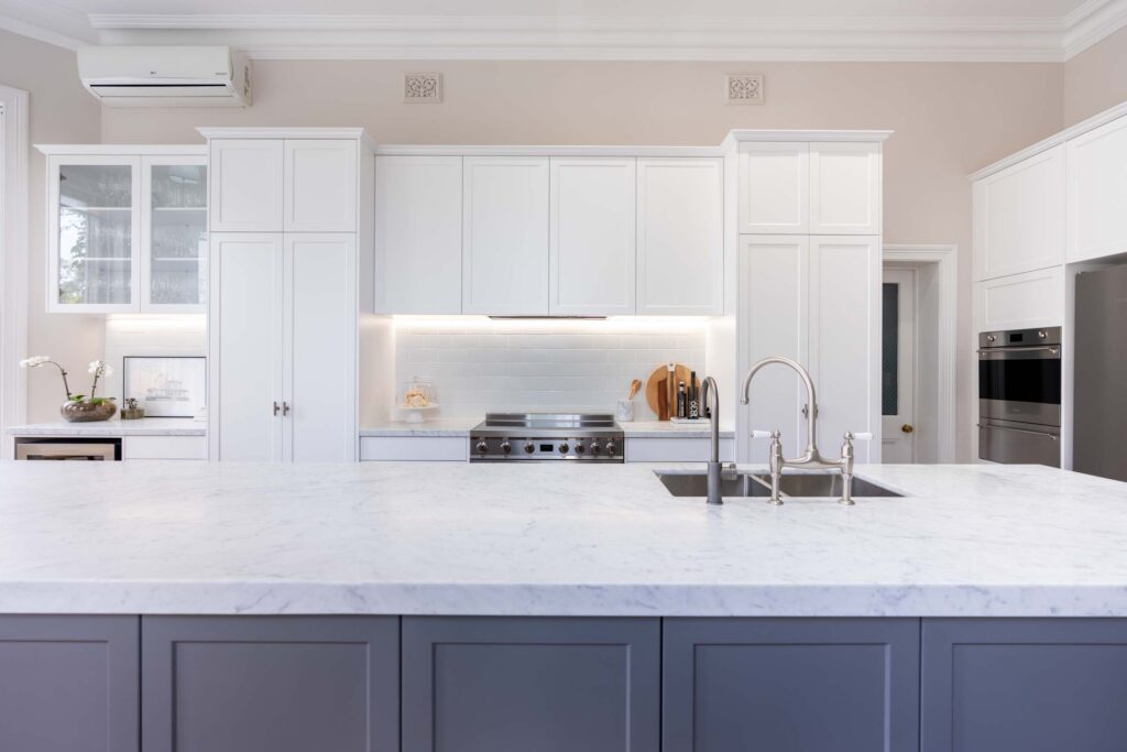 Hamptons style, elegant two tone kitchen with traditional elements, shaker style cabinets and Carrara marble benchtops.