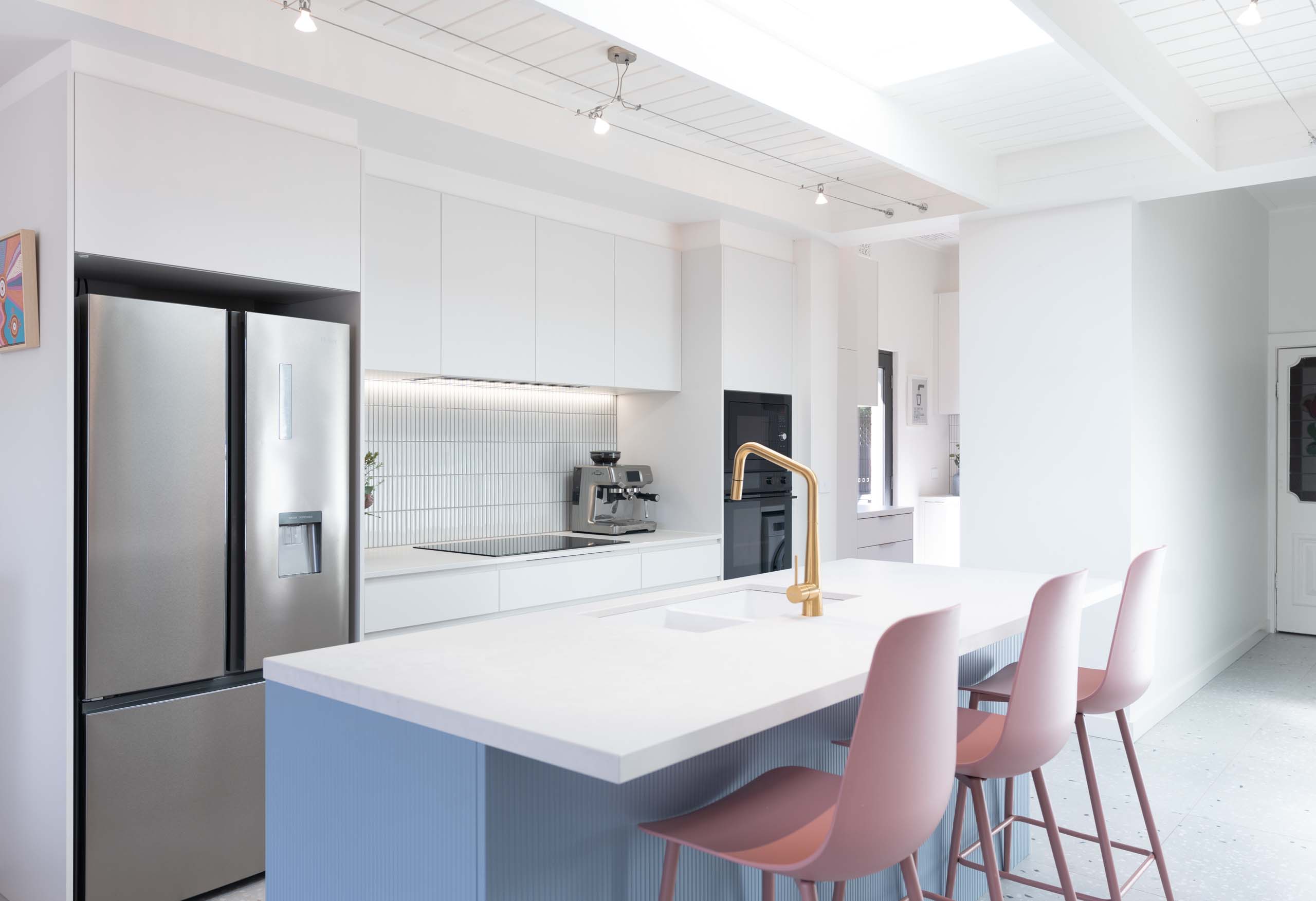 White Galley style kitchen with a Denim blue vertical striped island bench and pops of colour