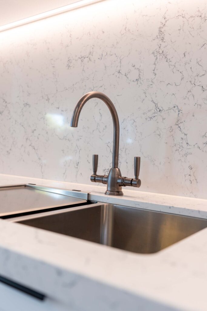 A traditional style sink and tap in gunmetal works well with colour of the space.