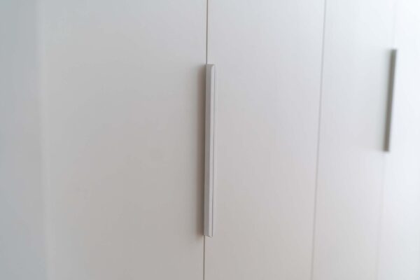 White grey Suedette matte cabinetry with slim white long handles.