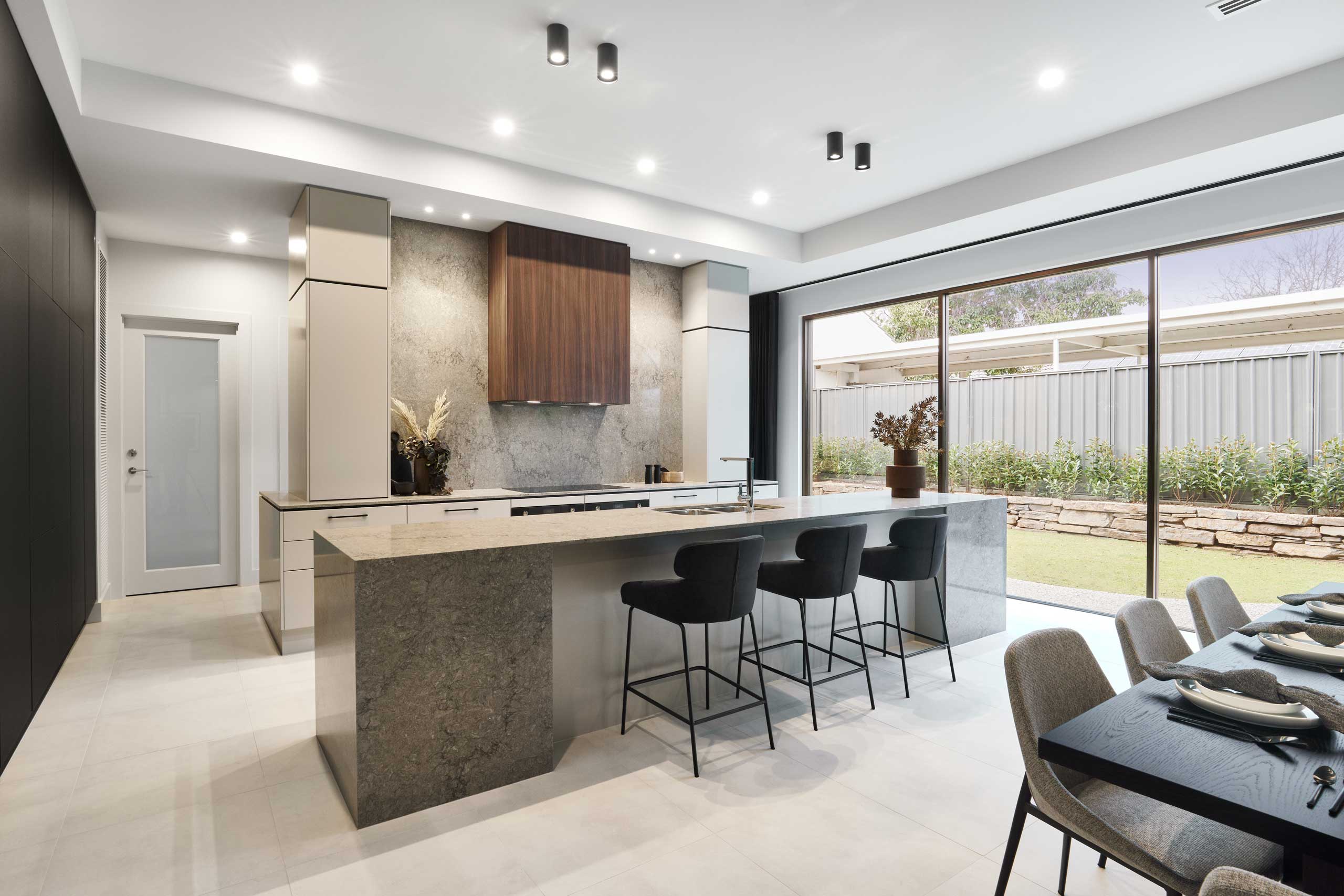 Galley Kitchen. High end design, grey stone benchtop, with pearl grey gloss cabinetry and Jarrah feature rangehood panel.