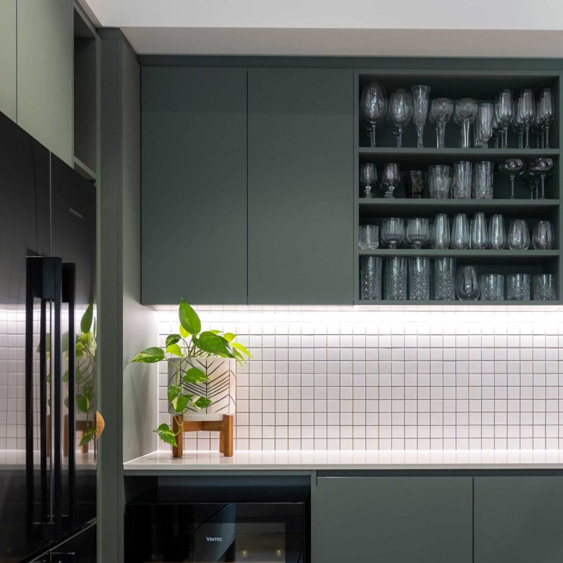 Slate green over heads with open shelving, paired with small white square tiles adding a natural feel.