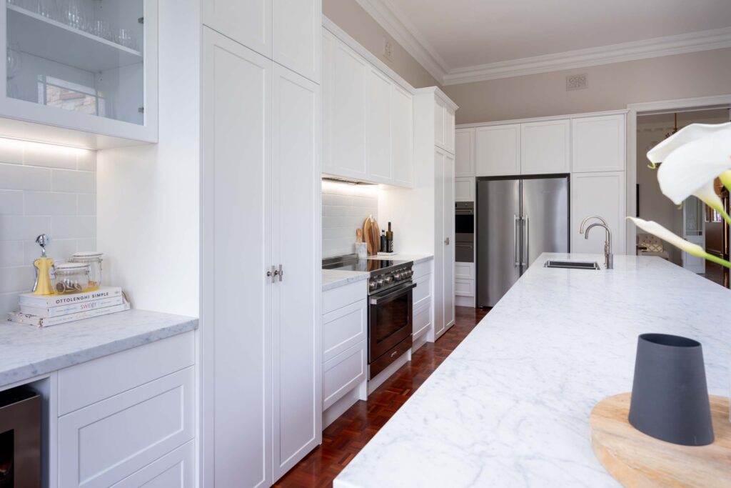 Elegant two tone kitchen, galley style with tradtional elements. Freestanding cooker and Carrara marble benchtops. 2 Pac satin Vivid White and Basalt Island. Dulux colours.