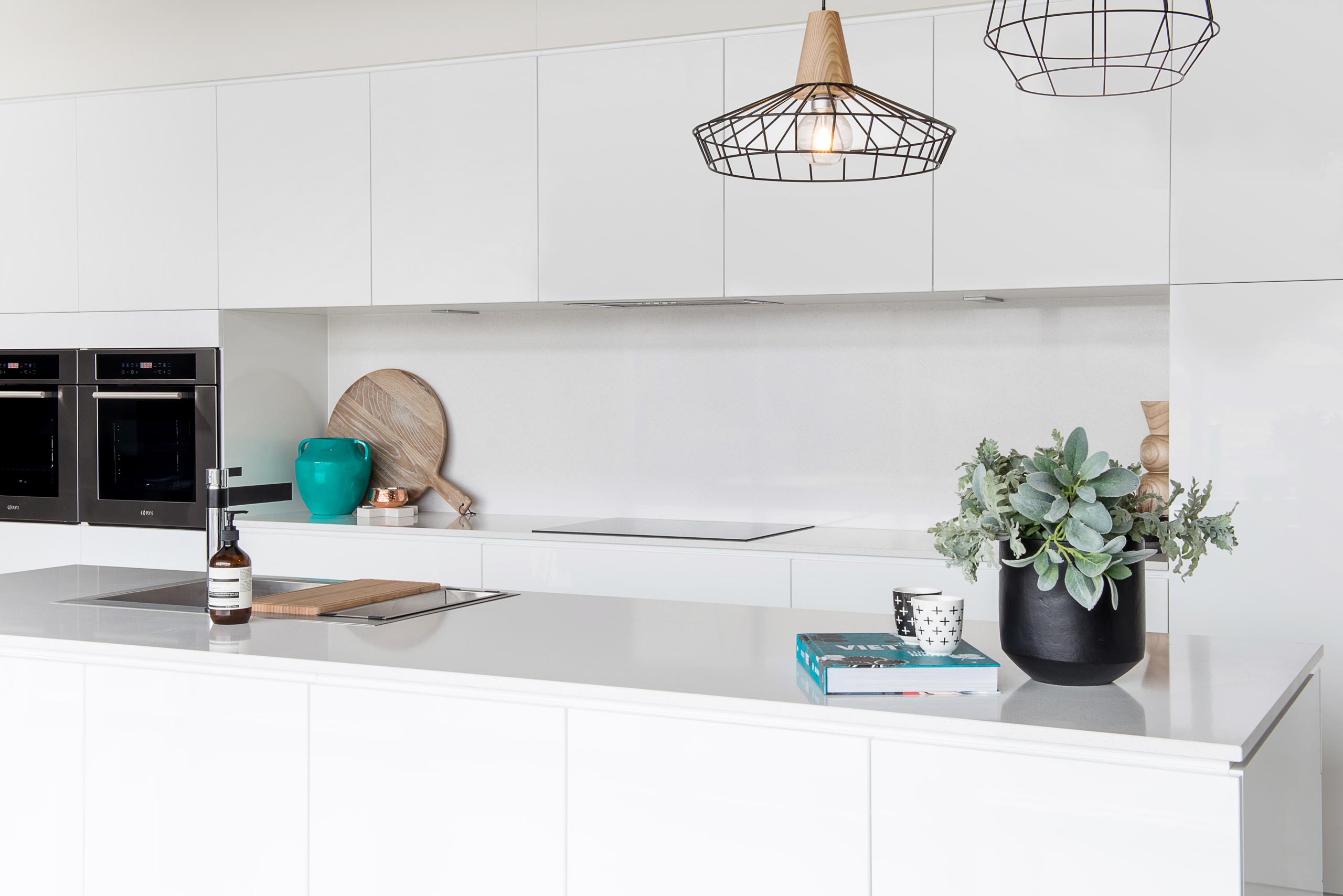 Farquhar form Gloss white Kitchen with push to open Cabinetry. Galley style Kitchen with complimentary white stone benchtop.