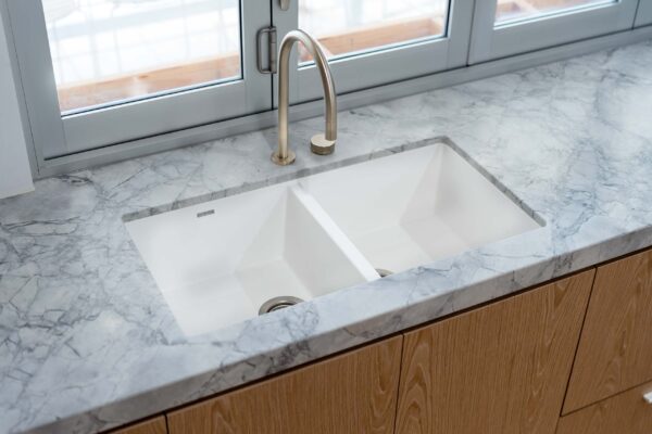 Oliveri white double undermount sink with brush brass tap, marble grey tone benchtop