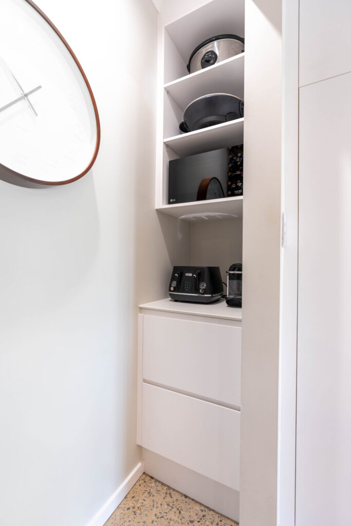 Pantry. Classic white walk in pantry with shelving and draws for storage.