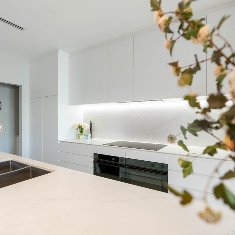 Kitchen. Classic white open galley kitchen with double ovens with open doorway to walk in pantry.