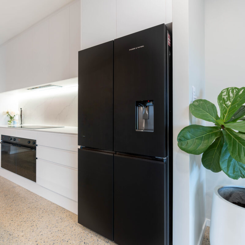 Fridge. Black fisher and Paykel double door fridge in white classic galley kitchen.