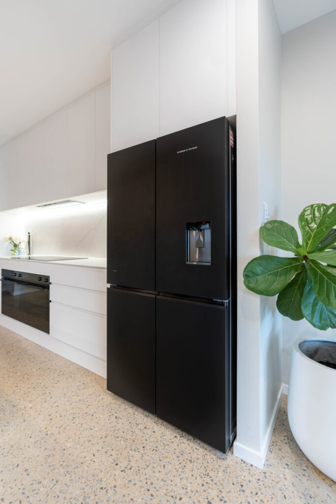 Fridge. Black fisher and Paykel double door fridge in white classic galley kitchen.