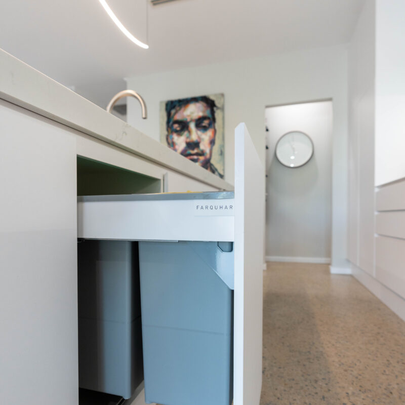 Kitchen with island bin draw pull out on polished concrete floor.