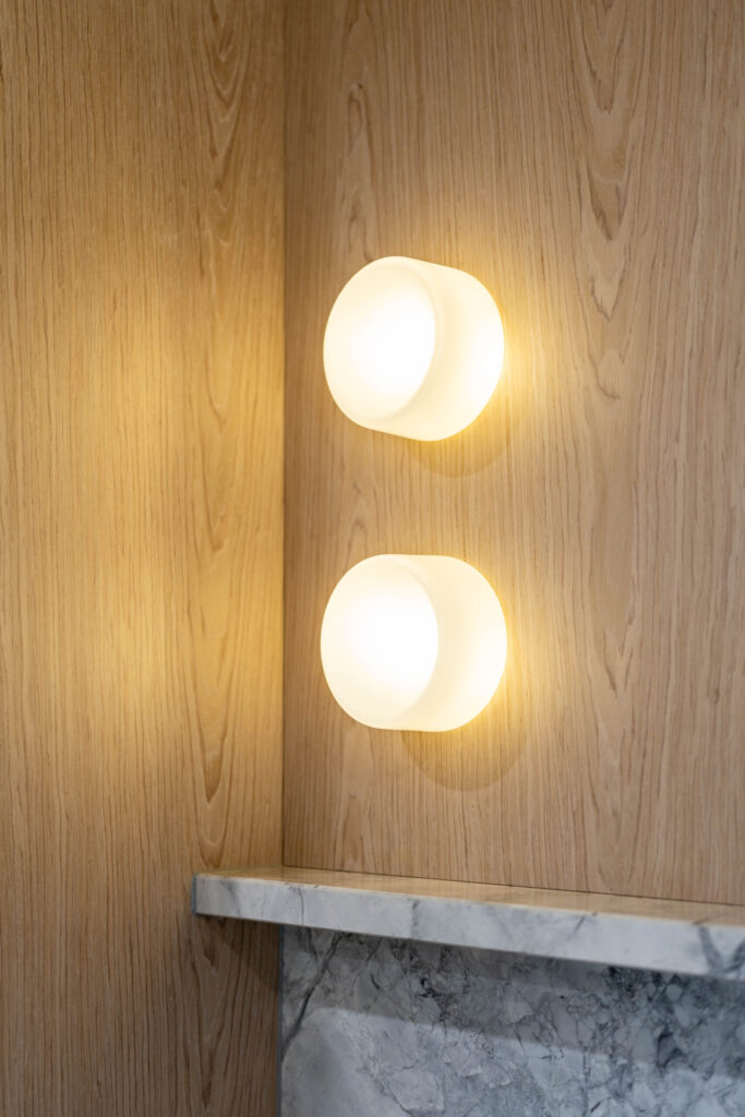 Kitchen. The detailed design of the stone on the shelving. Beautiful blond timber with round led lights featured.