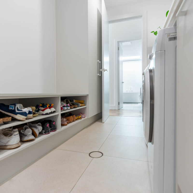 Laundry. Calming Curves. Bright white and crisp. shelving and storage space a plenty. With Mudroom shoe storage and seating bench.