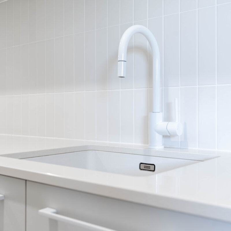 Laundry. Calming Curves. Bright white and crisp. Large kit kat tiles with White sink and tap