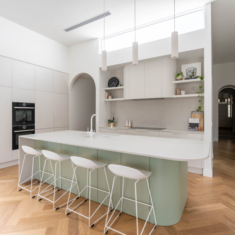 Kitchen. Calming curves. Soft and delicate curves in a two tone look in Laminex Bayleaf cabinetry and Farquhar white grey. Open plan with white pendants.