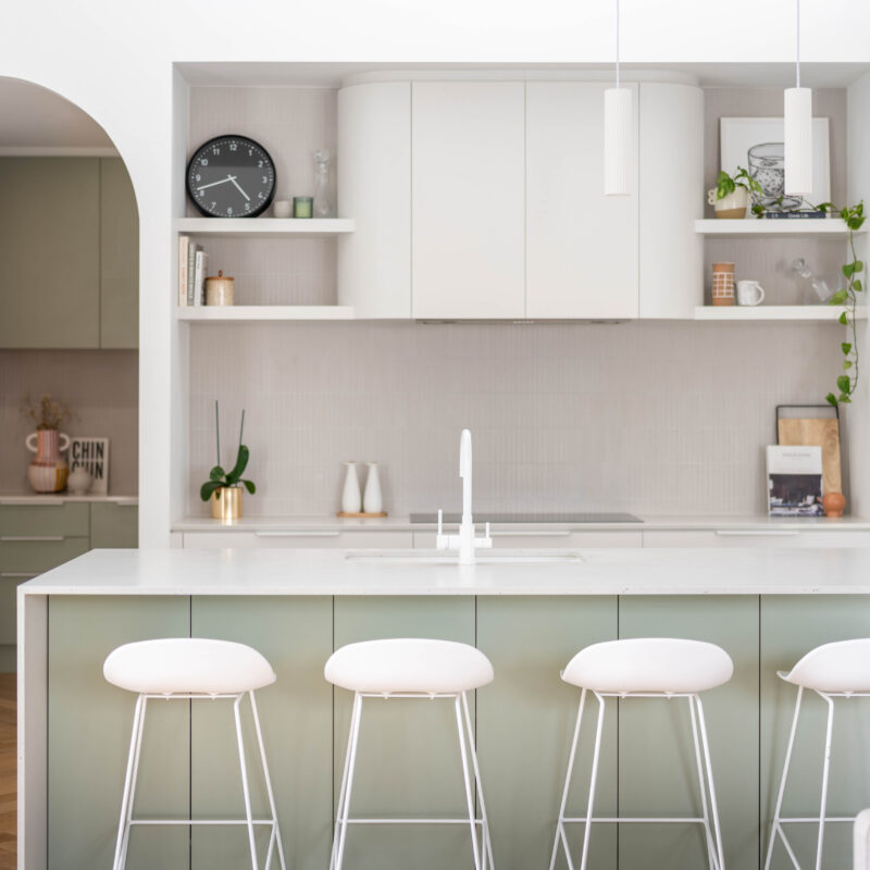 Kitchen. Calming curves. Soft and delicate curves in a two tone look in Laminex Bayleaf cabinetry and Farquhar white grey. Open plan with white pendants and white stools and accents