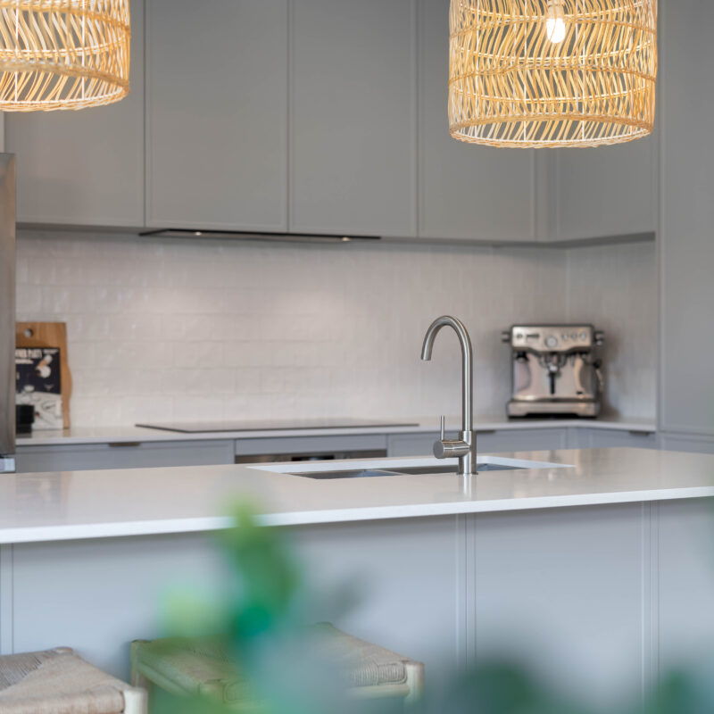 Kitchen in Farquhar Pearl grey Kiev profile. L shape light and natural. Fresh and coastal. Draws and upper cabinetry, zenith style white truffle benchtop and natural pendants.