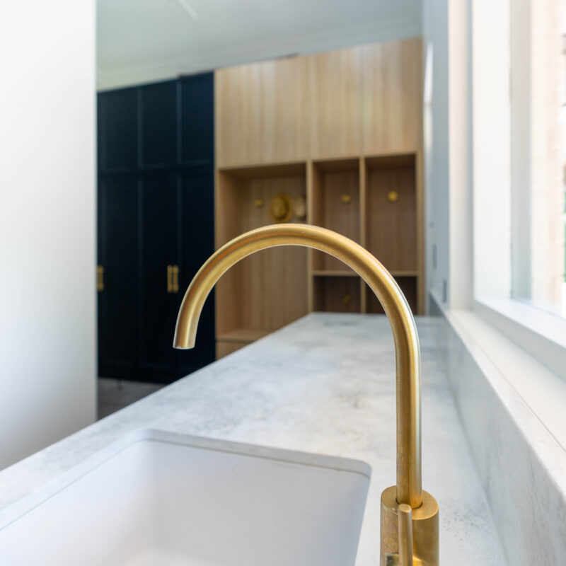 Laundry and butlers pantry cabinetry two tone with gold tap and stone benchtop