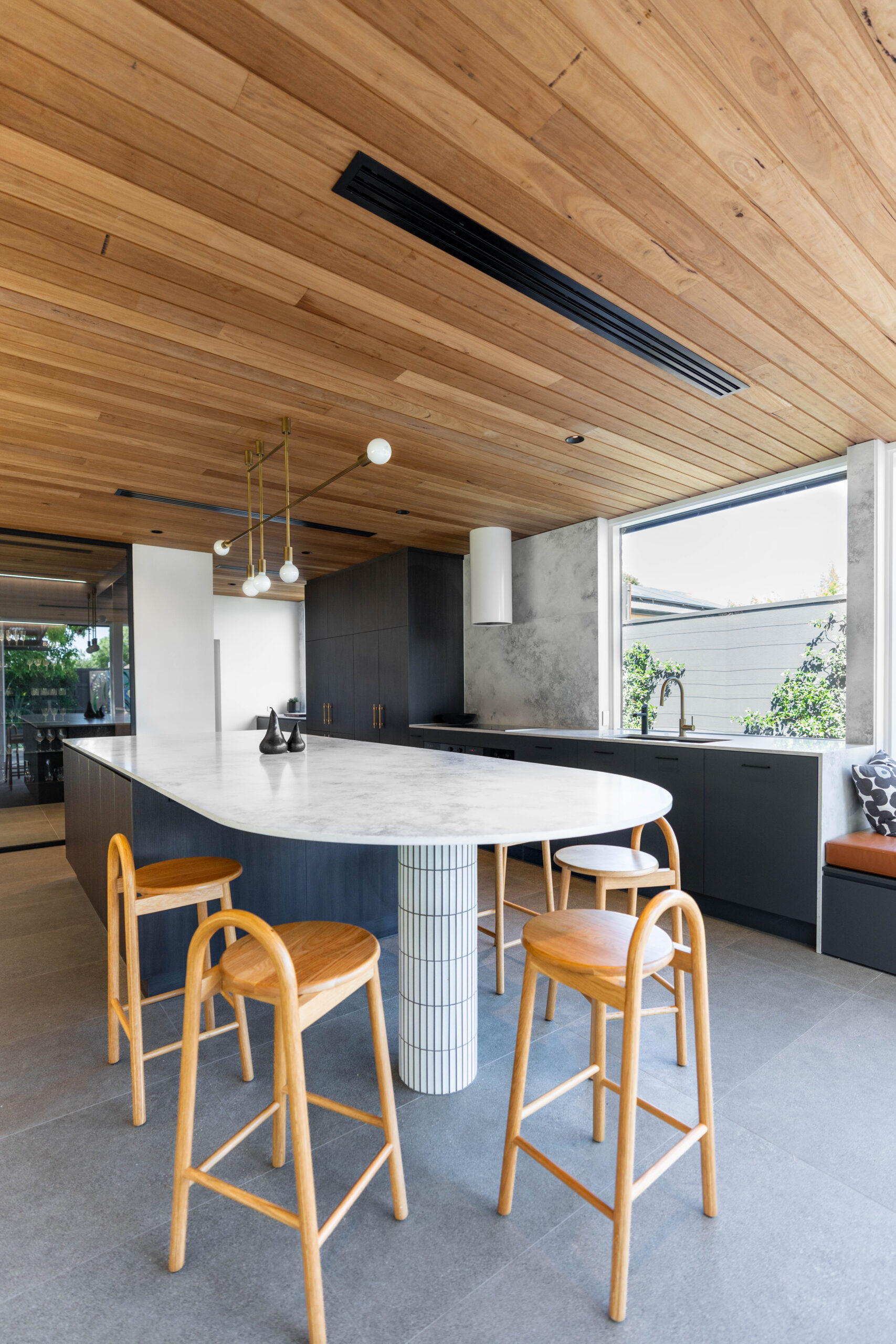 The seating end of the benchtop features a kit kat tiled column support, adding further texture and detail, later reflected in the splashback of the butlers pantry. Functionality The use of integrated appliances, double ovens, a butler's pantry and second workspace provide amenity for food prep and clean up, and a long and wide island bench is perfect for the family to enjoy casual meals and entertaining. Contrast Laundry The laundry and mudroom is large and practical, without skimping on style. Warm classic oak and indigo blue cabinetry creates a light and dark contrast, complemented by gold hardware and balanced with cool grey benchtops and tiling.