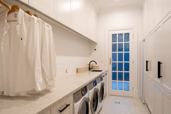 Laundry white Barossa profile with hanging rails and washing machine spaces for three.