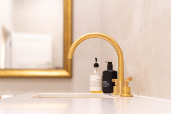 Gold tapware and mirror in bathroom