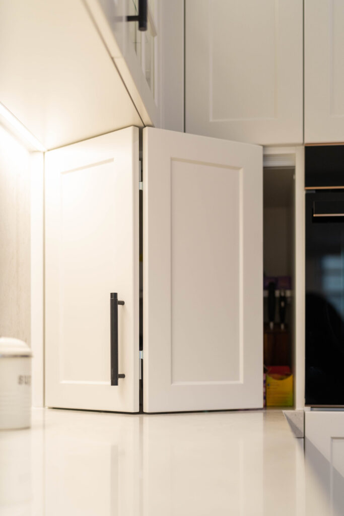 Hidden appliance nook, white Barossa profile with Black pull handle on a white stone benchtop.