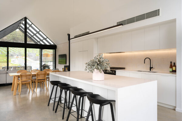 Black A line framed windows. Kitchen with Black Fisher and Paykel freestanding oven and cooktop with black tap create a bold contrast with the run of white profile cabinetry.