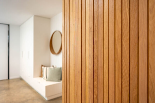 Timber oak slatted wall with adjacent mud room seating nook and storage.