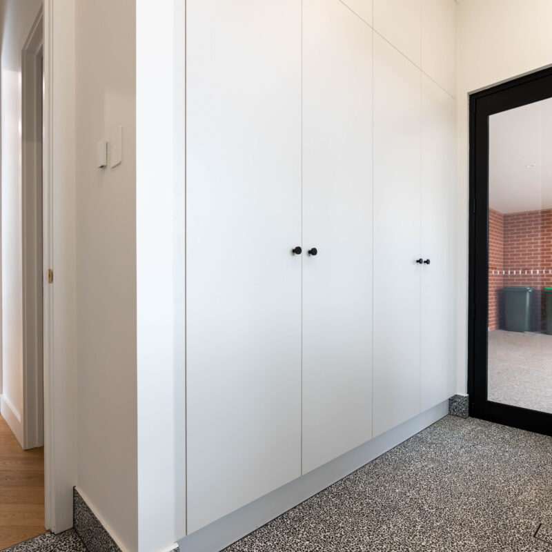 Laundry Linen. White tall cupboards on a terrazzo floor.