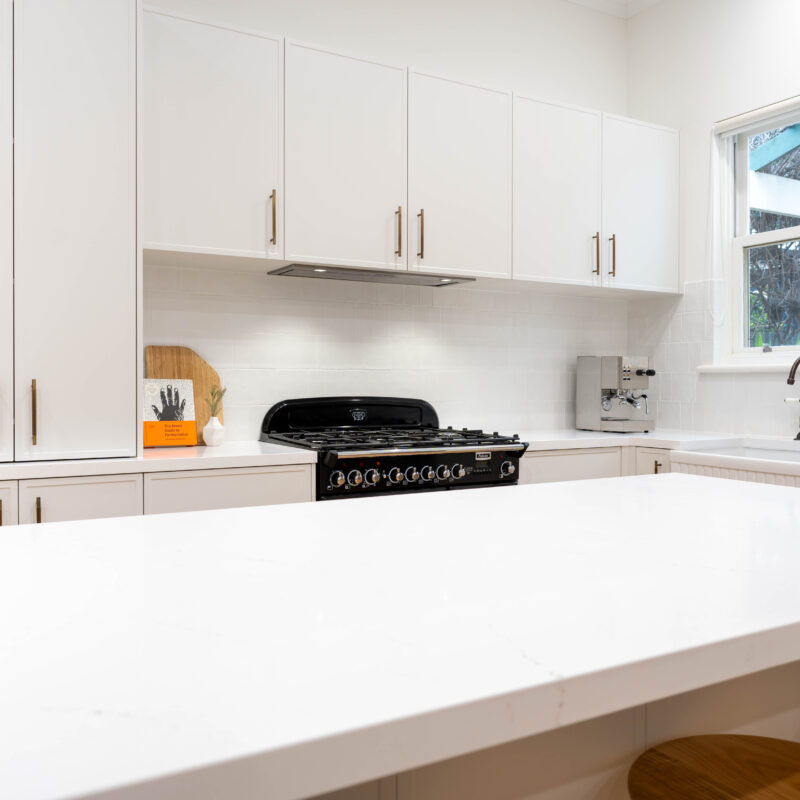 American style Farmhouse kitchen. White grey Farquhar Suedette matte Kiev 20 L shaped kitchen with an island and statement freestanding cooker and traditional hardware.