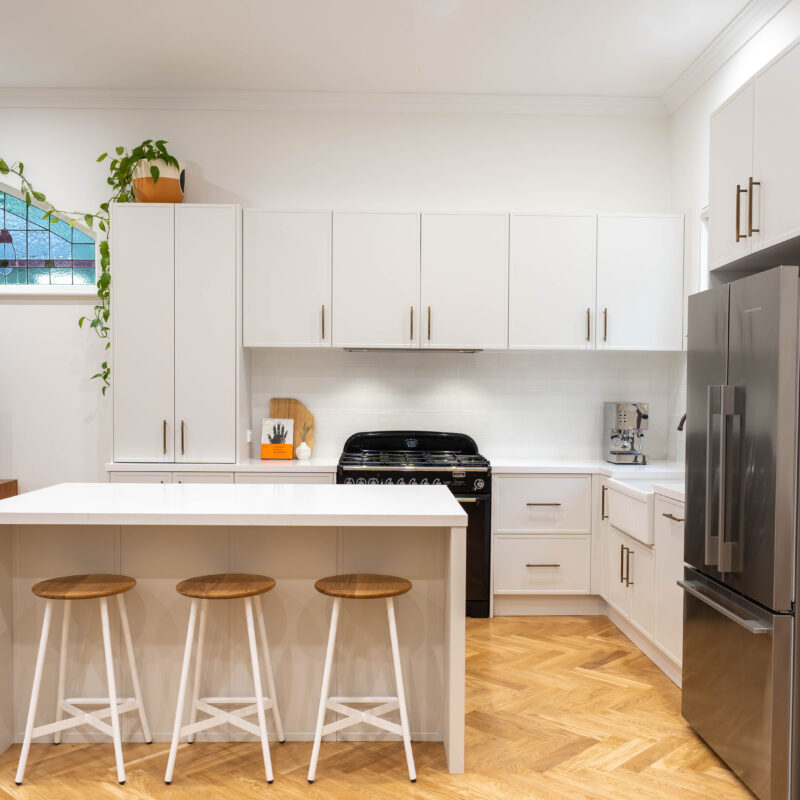 Open plan. American style Farmhouse kitchen. White grey Farquhar Suedette matte Kiev 20 L shaped kitchen with an island and statement freestanding cooker and traditional hardware.