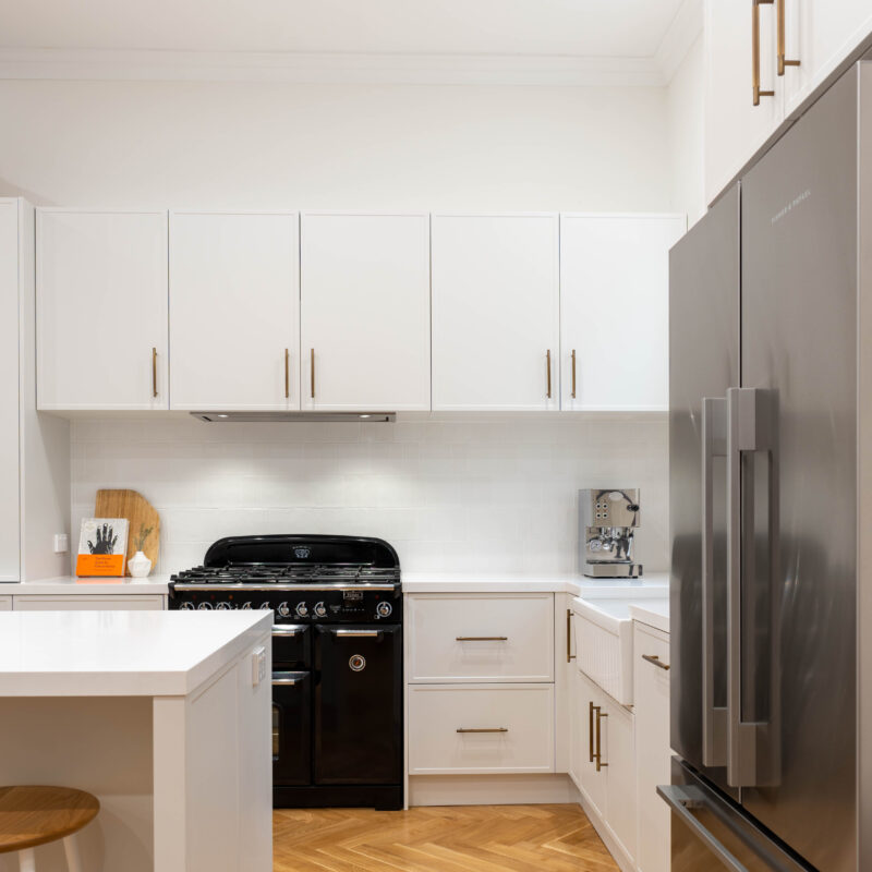 Open plan. American style Farmhouse kitchen. White grey Farquhar Suedette matte Kiev 20 L shaped kitchen with an island and statement freestanding cooker and traditional hardware. and fisher and paykel quad door fridge and freezer