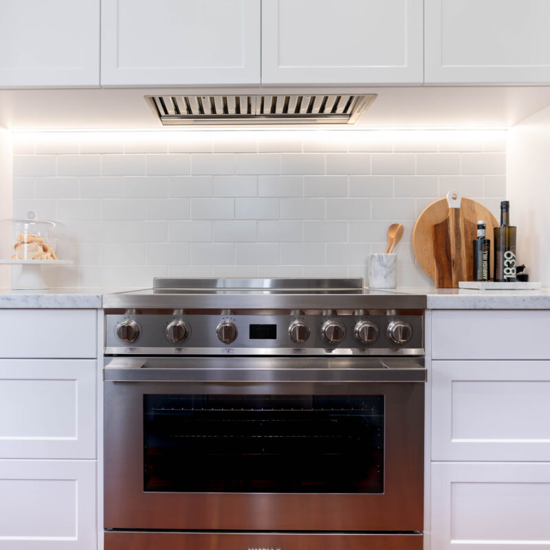 The core kitchen space is balanced and mirror image. Extending down towards the windows, the kitchen transforms into an entertaining space; with a glass door cabinet, wine fridge, and space for four stools, mimicking a traditional table setting, with two either side.