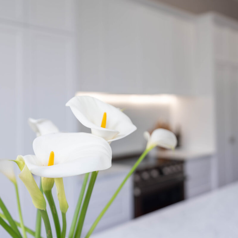 The core kitchen space is balanced and mirror image. Extending down towards the windows, the kitchen transforms into an entertaining space; with a glass door cabinet, wine fridge, and space for four stools, mimicking a traditional table setting, with two either side.
