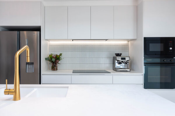 White kitchen with kit kat tiles with well balanced appliances.