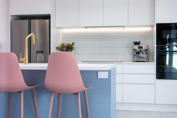 The kitchen’s masterpiece is the central island, clad in vertical striped profile Form Matte panels in a vibrant denim blue. The island is ultra functional for the family, with the kids often eating their meals at the pink stools.