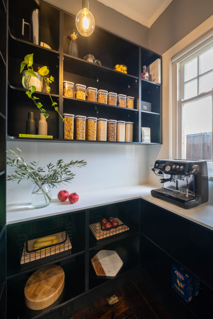Touch Cabinetry. Black walk in pantry with white stone benchtop. L shape with open shelving for storage