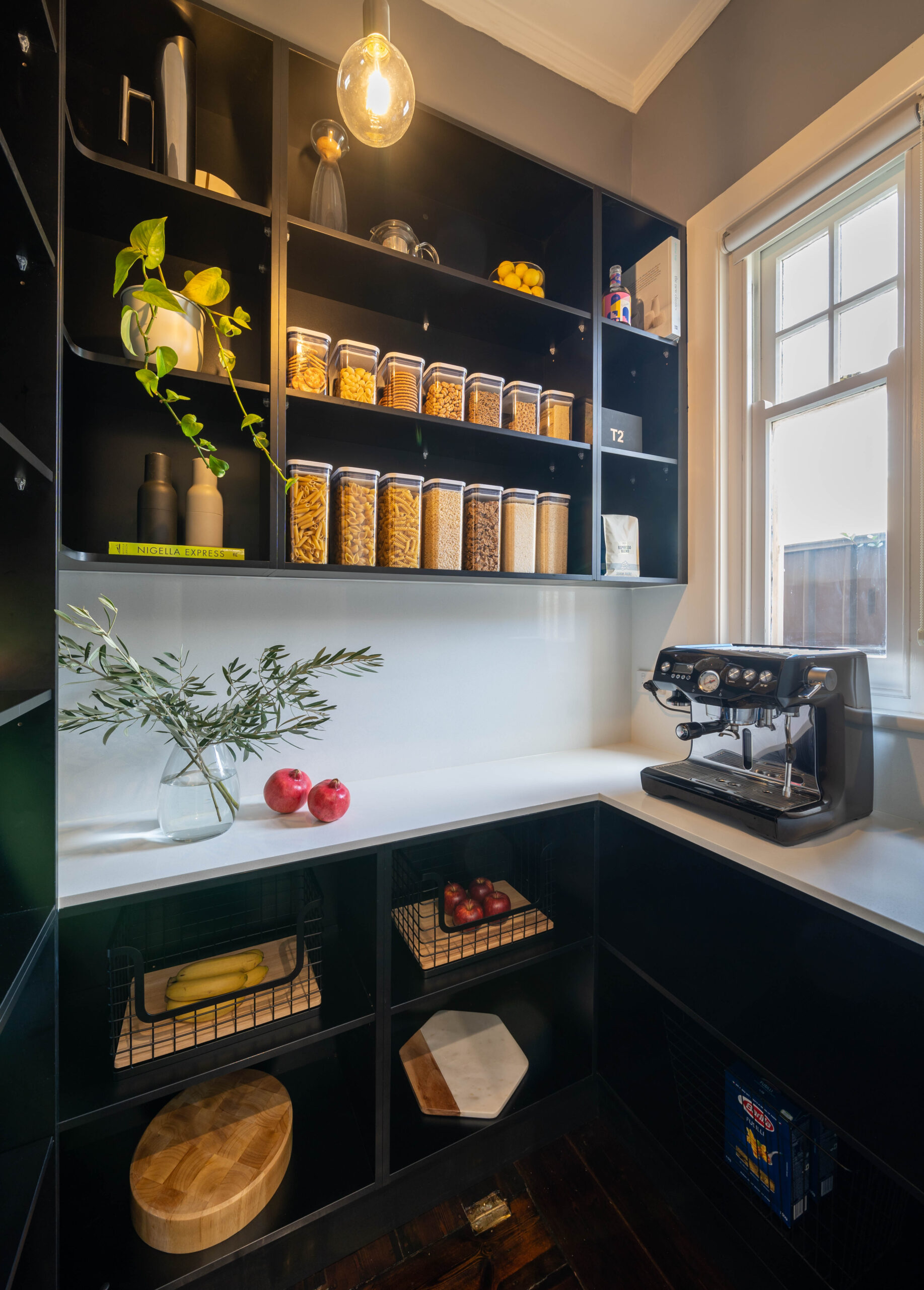 Touch Cabinetry. Black walk in pantry with white stone benchtop. L shape with open shelving for storage