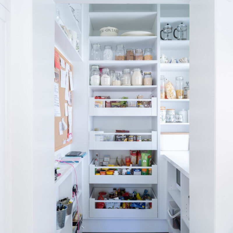 Walk in pantry, white and light full of pull out see through draws and cabinet space storage.