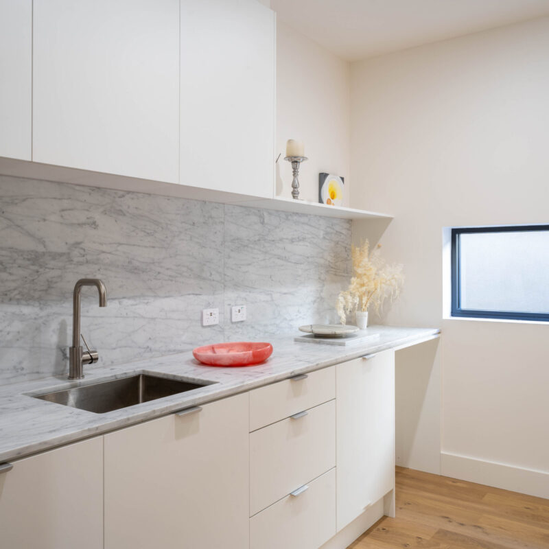 Butlers pantry. Slim line and clean lines. Flowing from the kitchen. Marble backsplash and benchtop with White touch cabinetry.
