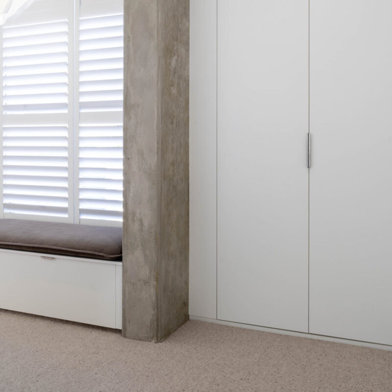 Walk in robe space. Open space with a large run of white cabinetry for storage.
