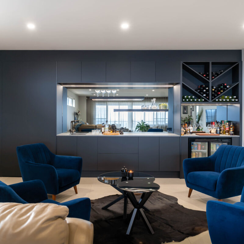 Modern home bar in black touch cabinetry. Handle less Cabinetry and clean lines streamline the design, cleverly disguising the function and storage hidden within.