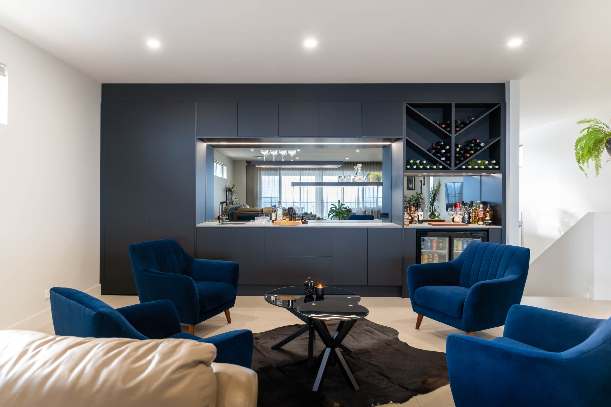 Modern home bar in black touch cabinetry. Handle less Cabinetry and clean lines streamline the design, cleverly disguising the function and storage hidden within.