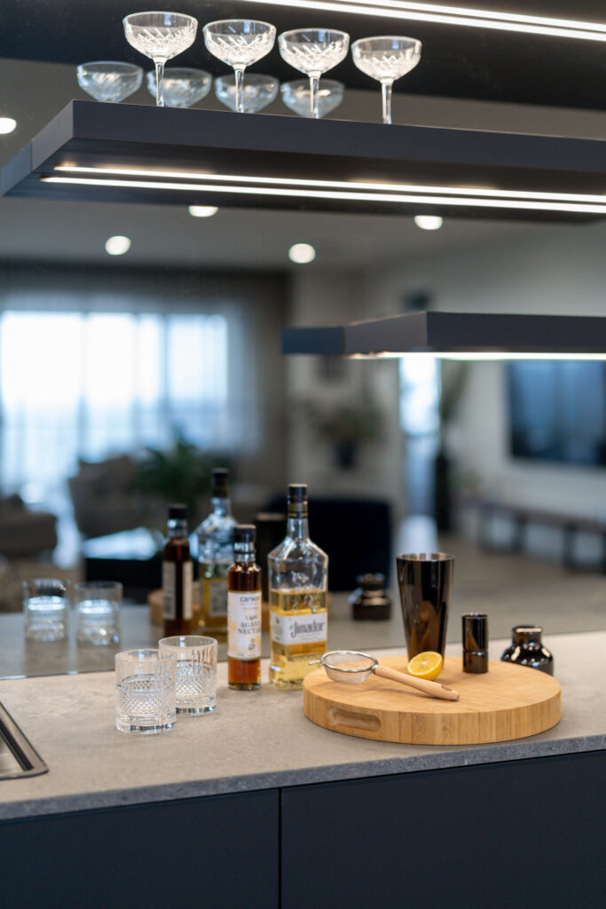 Entertainers Bar with concrete look benchtop, mirrored splashback and shelving for displays.