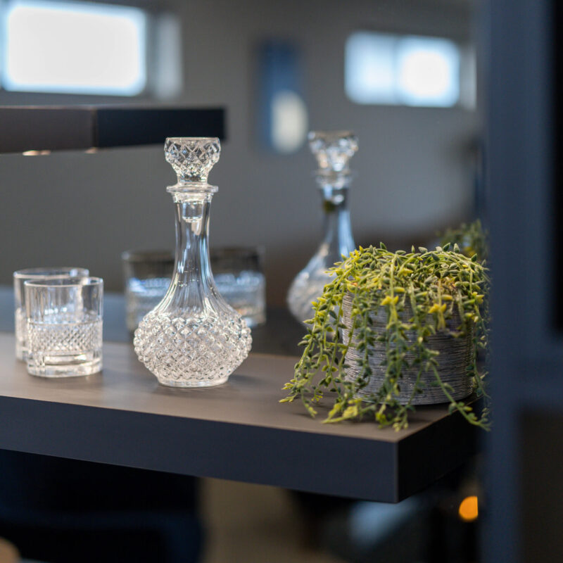 Entertainers Bar with concrete look benchtop, mirrored splashback and shelving for displays.