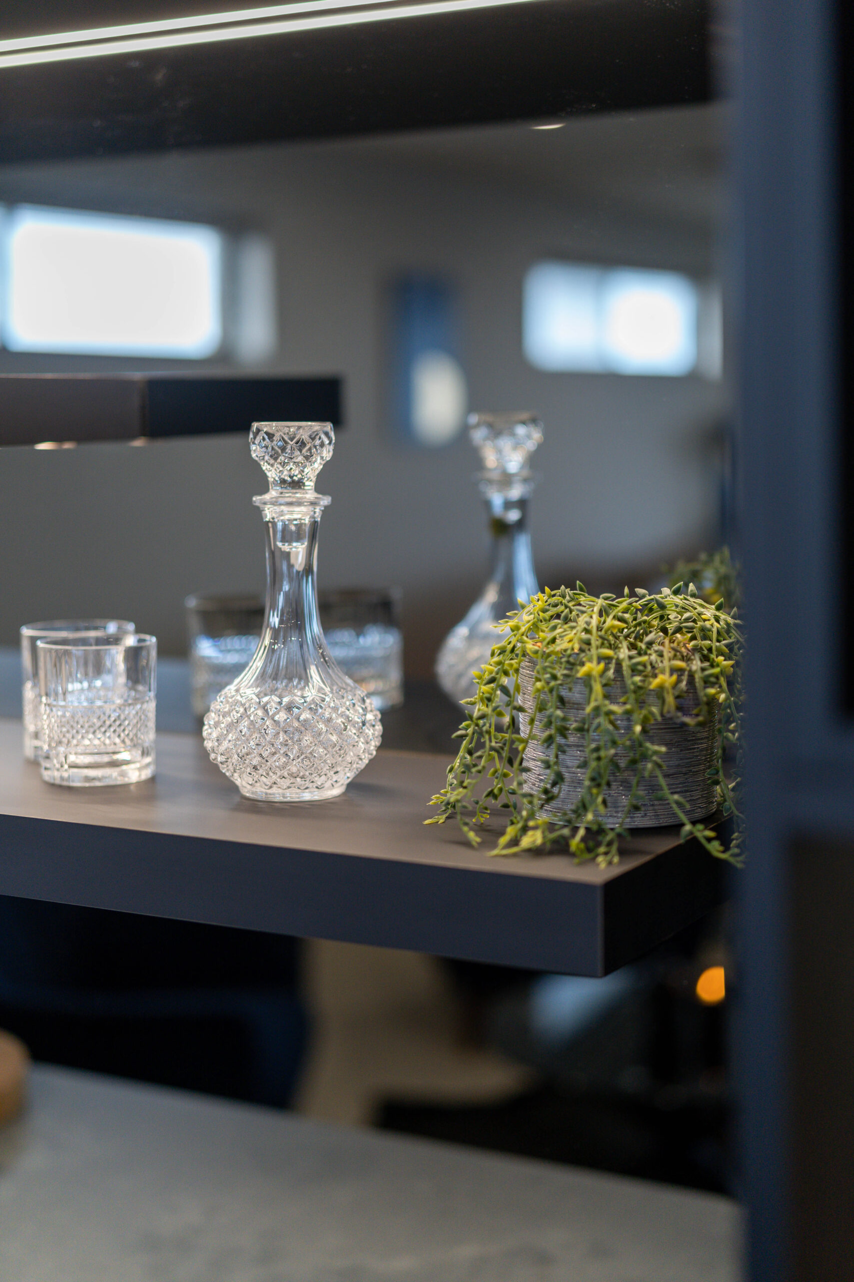 Entertainers Bar with concrete look benchtop, mirrored splashback and shelving for displays.