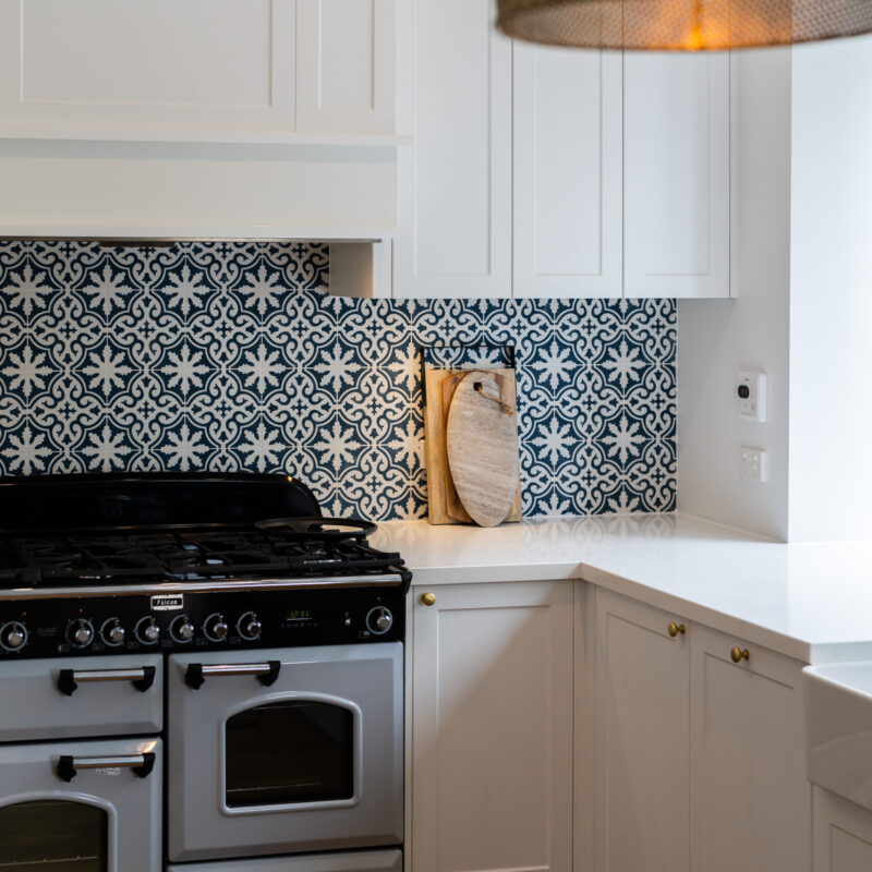 Traditional twist kitchen. Navy, white and gold. Over heads in Farquhar Barossa profile with small glass inserts.