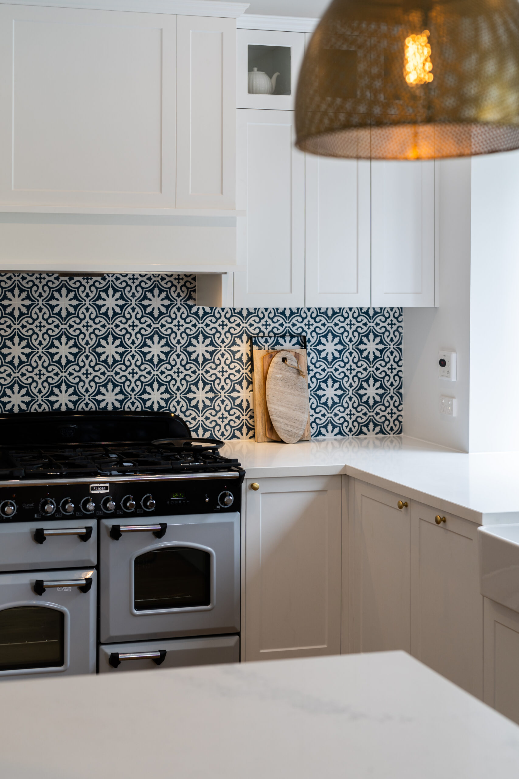 Traditional twist kitchen. Navy, white and gold. Over heads in Farquhar Barossa profile with small glass inserts.