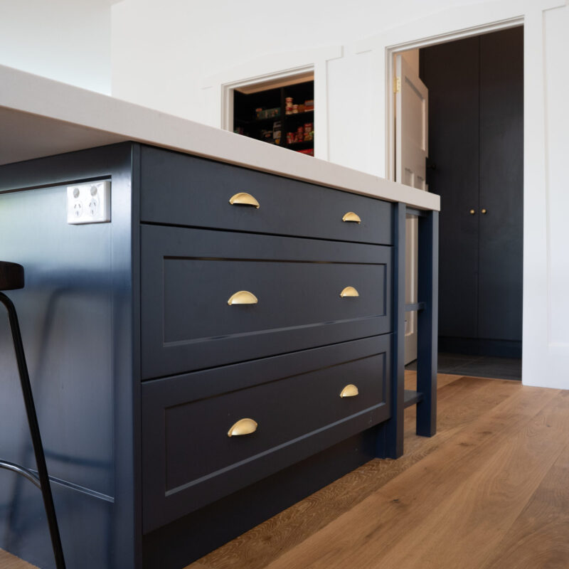 Navy Island bench. Traditional Twist Farquhar Kitchen. gold cup handles and gold pendant light with white stone benchtop.