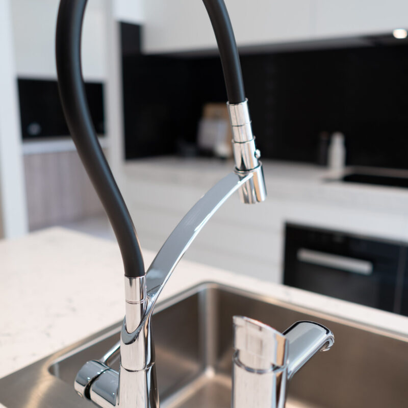 Sink and Tap in kitchen island- Mixer tap black and silver, alongside a zip tap.