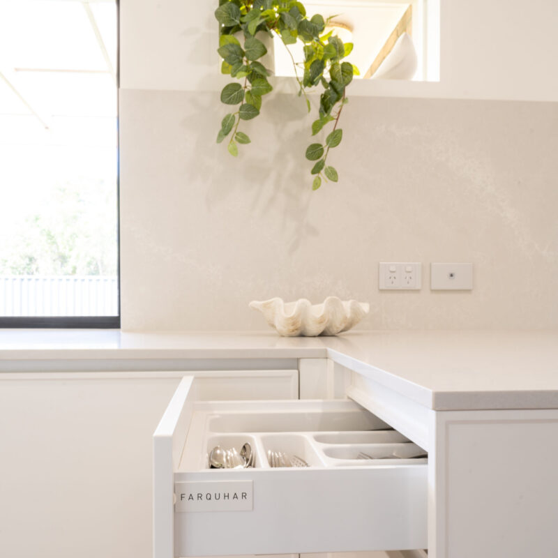 White Kitchen in a simple design. Draw units with Farquhar badge in Farquhar Kiev 10 Profile with stone splashback and benchtop.
